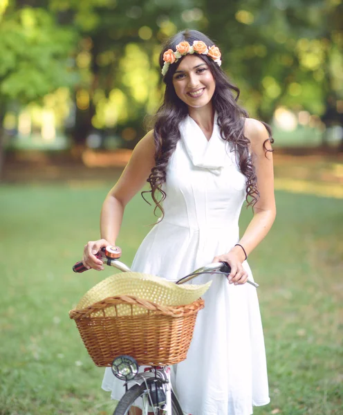 Beautiful woman riding bicylce in park and enjoying beautiful su — Stock Photo, Image