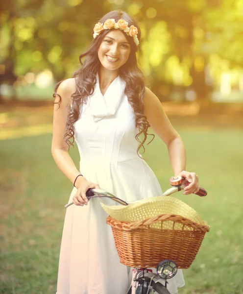 Beautiful woman riding bicylce in park and enjoying beautiful su — Stock Photo, Image