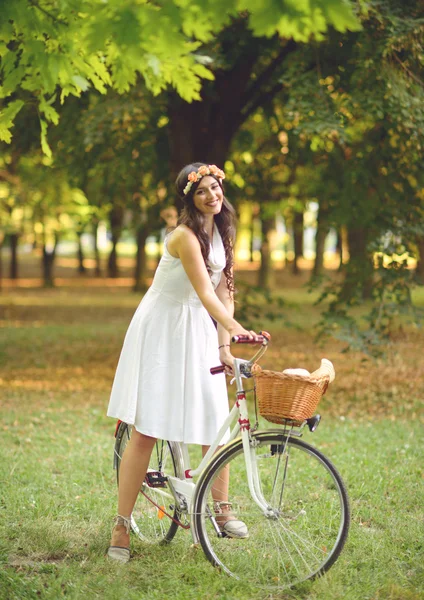 Hermosa mujer montando bicicleta en el parque y disfrutando de su hermosa —  Fotos de Stock