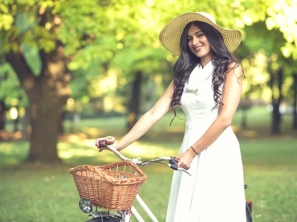 Beautiful woman riding bicylce in park and enjoying beautiful su — Stock Photo, Image