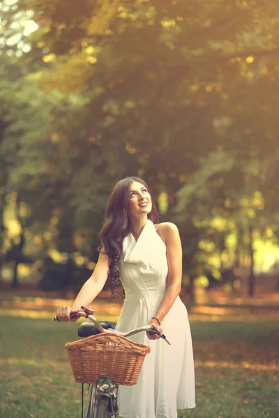 Szép nő, lovaglás kerékpár parkban, és élvezi a gyönyörű su — Stock Fotó