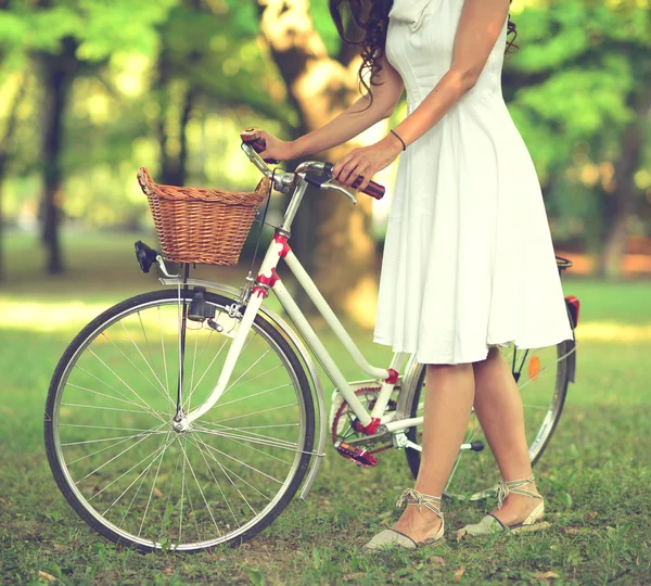 Beautiful woman riding bicylce in park and enjoying beautiful su — Stock Photo, Image