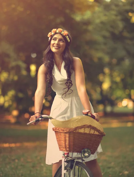 Beautiful woman riding bicylce in park and enjoying beautiful su — Stock Photo, Image