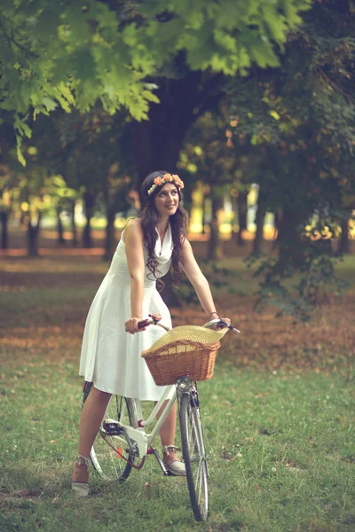 Krásná žena na koni jízdních kol v parku a užívat si krásné su — Stock fotografie
