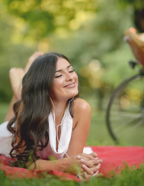 Mooie jonge vrouw, luisteren naar muziek buiten op het park — Stockfoto