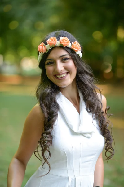 Retrato de una hermosa joven con corona floral en la naturaleza — Foto de Stock