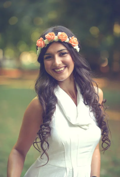 Retrato de una hermosa joven con corona floral en la naturaleza — Foto de Stock