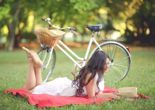 Junge schöne Frau liest Buch im Freien im Park auf einem sonnigen d — Stockfoto