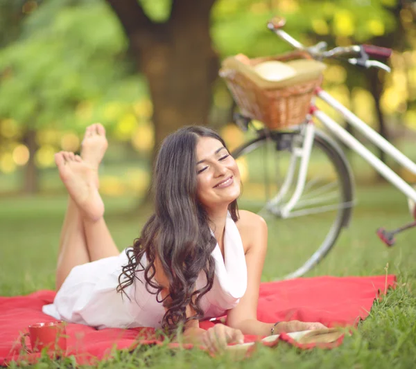 Mooie jongedame leesboek buiten in het park op een zonnige d — Stockfoto