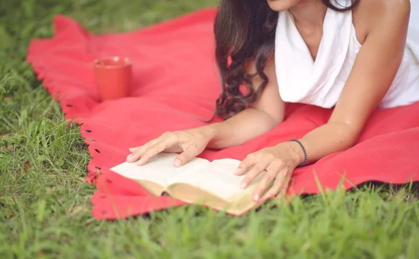 Молодая красивая женщина читает книгу на открытом воздухе в парке на солнечном d — стоковое фото