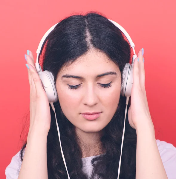 Portrait of happy teen girl dancing and listening music against — Stock Photo, Image