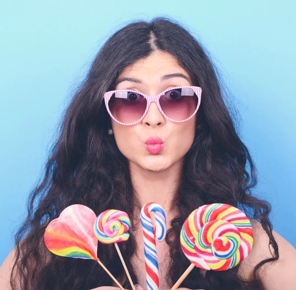 Retrato de mujer con gafas retro y piruletas contra azul — Foto de Stock