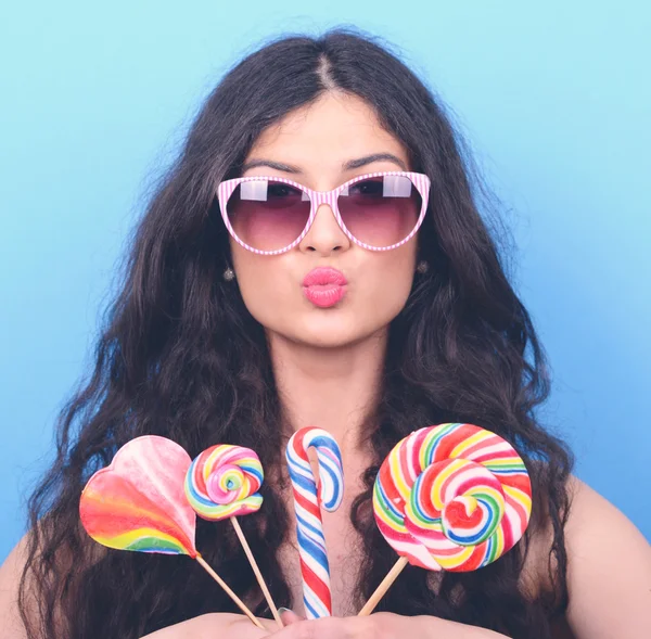 Portrait of woman with retro glasses and lollipops against blue — Stock Photo, Image