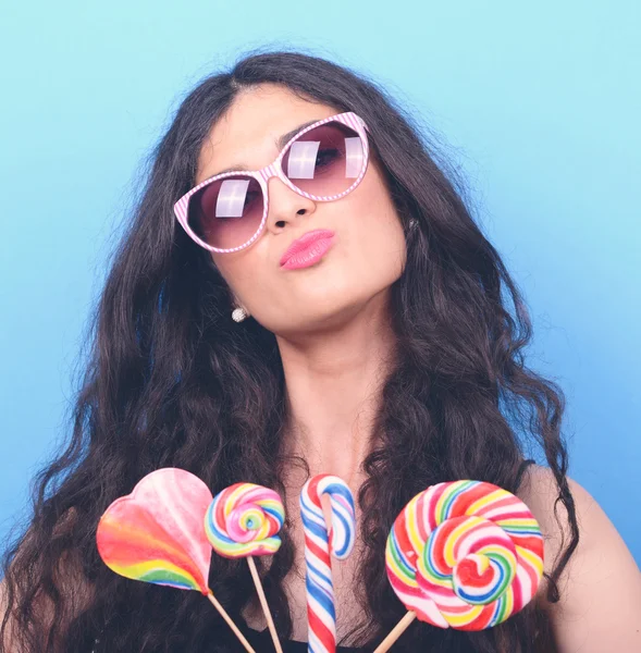 Retrato de mujer con gafas retro y piruletas contra azul — Foto de Stock