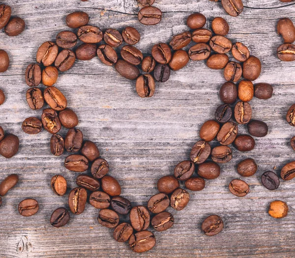 Coeur en forme de grains de café sur fond en bois — Photo