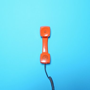 Mavi arka plan - Retro turuncu telefon tüp düz yatıyordu