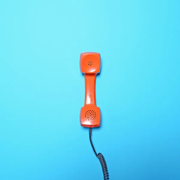 Retro orange telephone tube on blue background - Flat lay — Stock Photo, Image