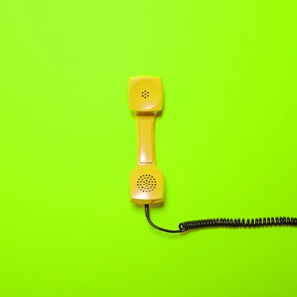 Tubo de telefone amarelo retro sobre fundo verde fluorescente - Mi — Fotografia de Stock