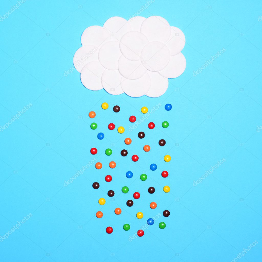 Multicolored sweets falling from cotton clouds against blue back
