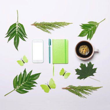 Yeşil yaprakları kelebek kitap kalemi ve hücre fon ile kahve