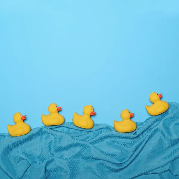 Fünf Gummi-Enten schwimmen im See aus wehender Seide - trendy — Stockfoto