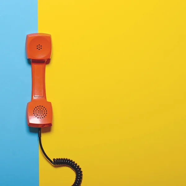 Tubo de telefone laranja retro em azul listrado e backgroun amarelo — Fotografia de Stock