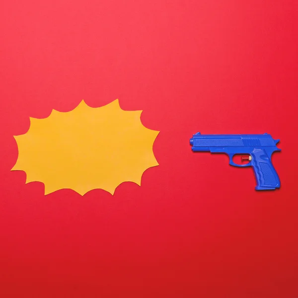 Pistolet jouet sur fond rouge avec ballon de bande dessinée vide - Mi — Photo