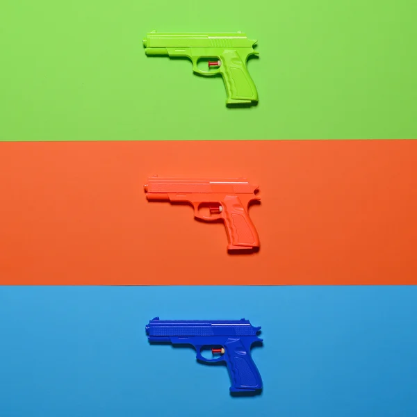 Pistolas de juguete sobre fondo colorido - Vista superior de diseño mínimo —  Fotos de Stock