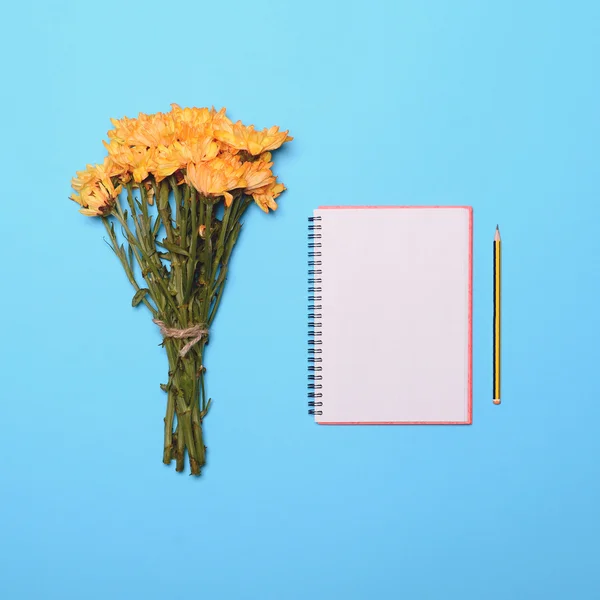 Bouquet of fresh yellow summer flowers and blank notebook and pe — Stock Photo, Image