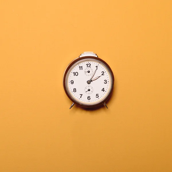 Reloj despertador marrón vintage sobre fondo ocre amarillo - Trendy mi — Foto de Stock