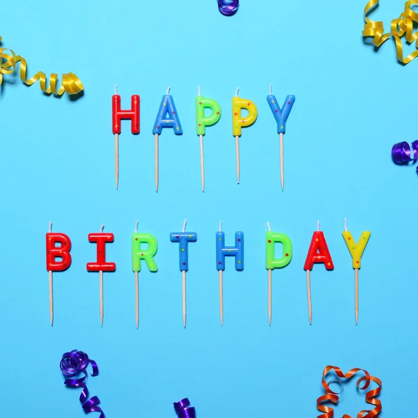 Happy Birthday flat lay party decorations on blue background