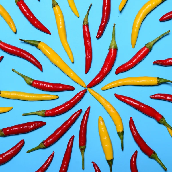 Pimientos picantes rojos sobre fondo azul - Puesta plana — Foto de Stock