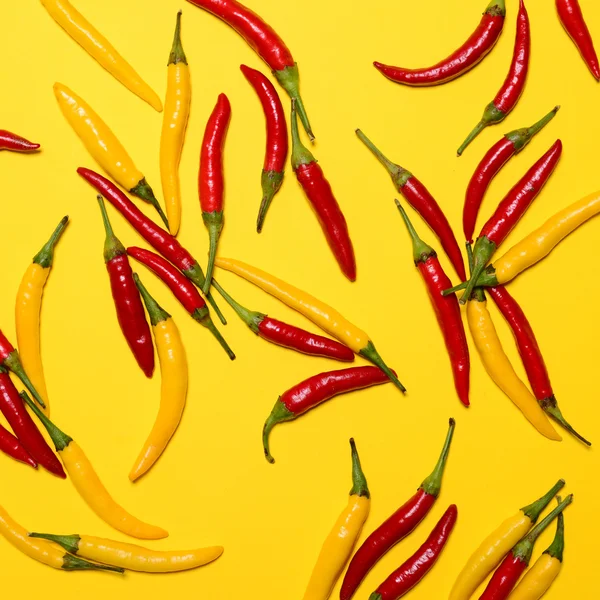 Red hot Red Hot chili peppers na żółtym tle - płaskim leżał — Zdjęcie stockowe
