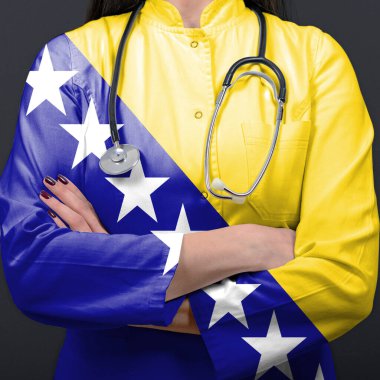 Sağlık sistemini Bosna-Hersek bayrağıyla temsil eden doktor
