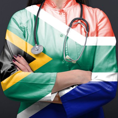 Güney Afrika ulusal bayrağıyla sağlık sistemini temsil eden doktor.