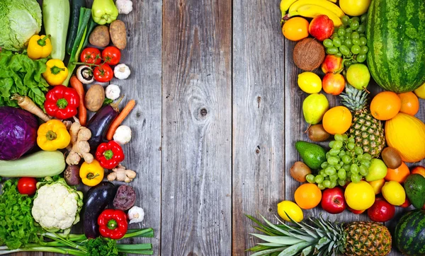 Enorme groep verse groenten en fruit op houten achtergrond - — Stockfoto