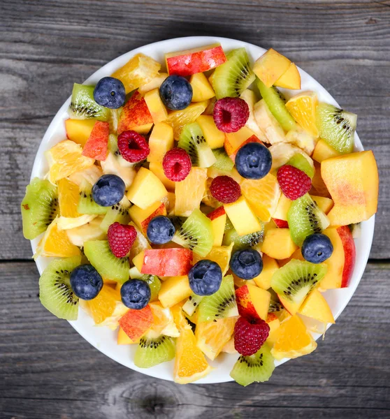 Vista superior de uma salada de frutas frescas com banana kiwi laranja blueber — Fotografia de Stock