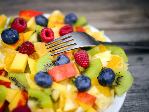 Macro shot of a fresh fruit salad with bananas kiwi orange blueb — Stock Photo, Image