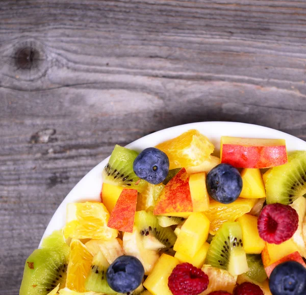 Top view of a fresh fruit salad with bananas kiwi orange blueber — Stock Photo, Image