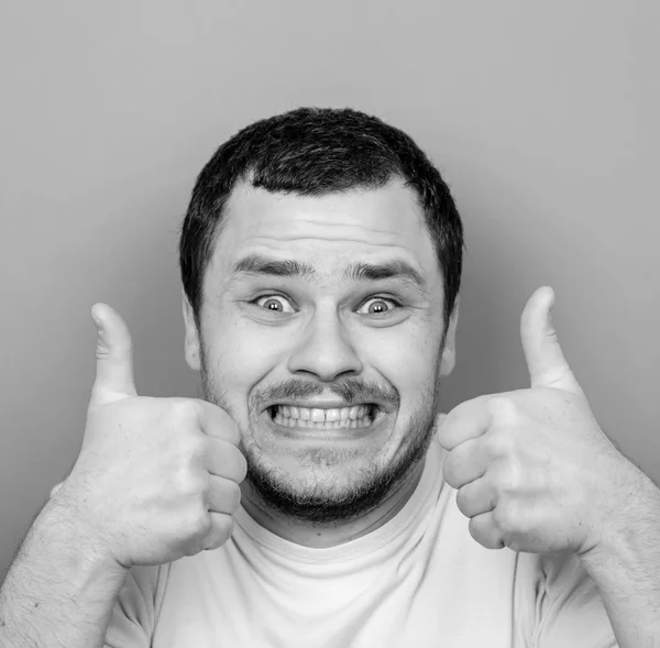 Portrait of with funny expression holding thumbs up - Monocrome — Stock Photo, Image