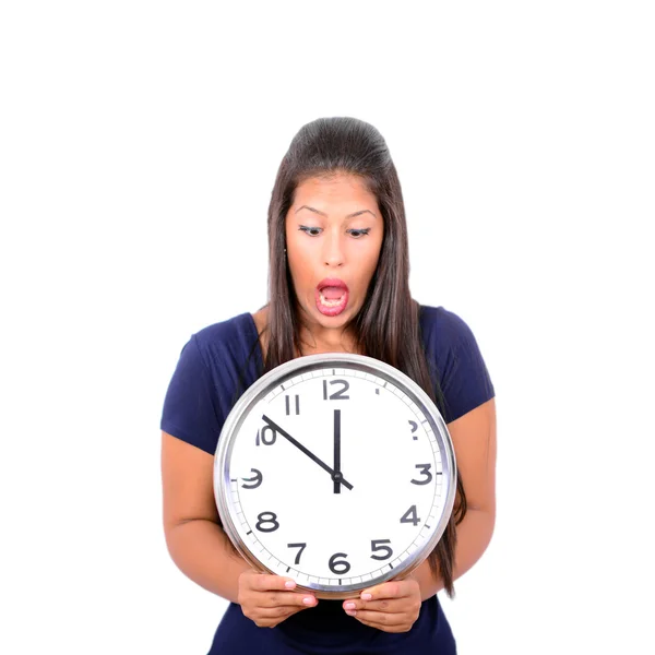 Portrait of a young female in shock holding big clock against wh — Stock Photo, Image