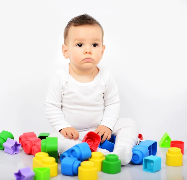 Mooie babymeisje met kleurrijke speelgoed - studio opname — Stockfoto