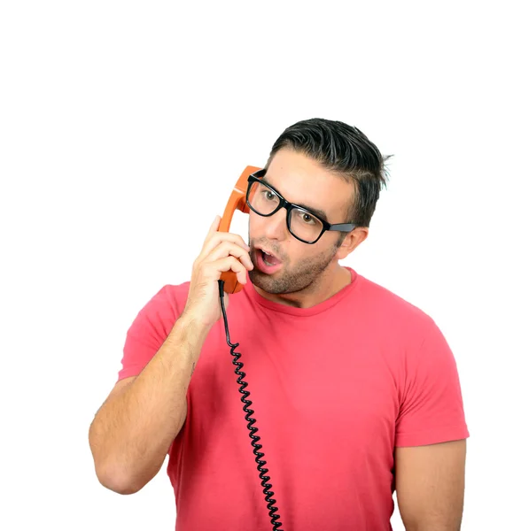 Portrait of young man in shock while talking on phone having unp — Stock Photo, Image