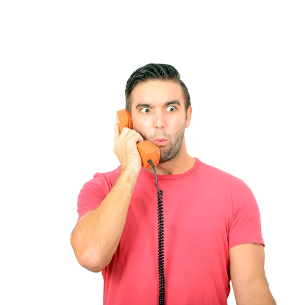 Portrait of young man in shock while talking on phone having unp — Stock Photo, Image