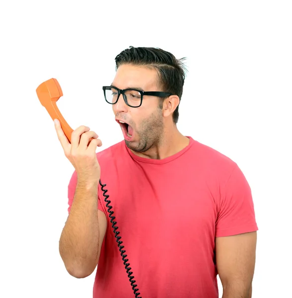 Portrait of young man yelling at phone against white background — Stock Photo, Image