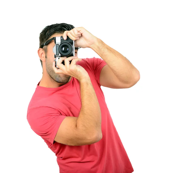 Молодий чоловік використовує ретро камеру на білому тлі — стокове фото