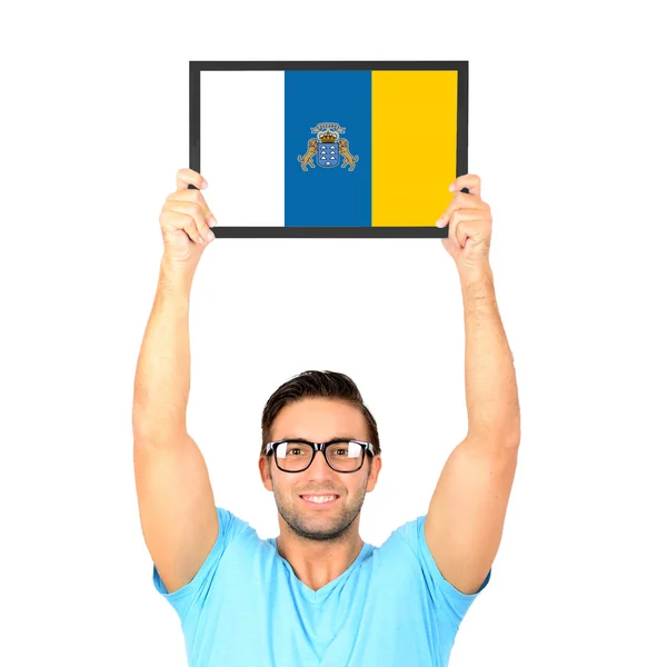 Portrait of a young casual man holding up board with National fl — Stock Photo, Image