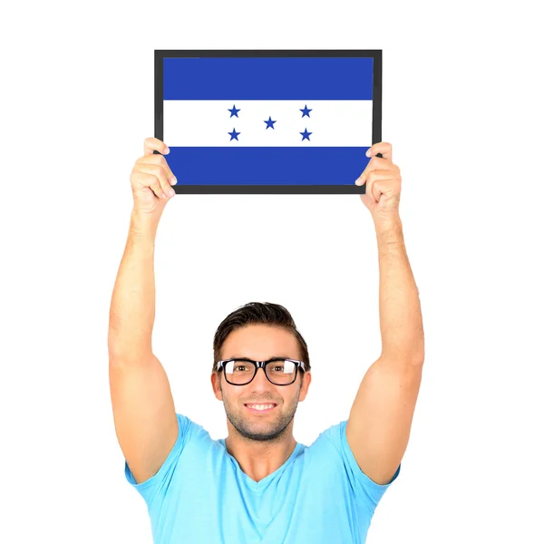 Portrait of a young casual man holding up board with National fl — Stock Photo, Image