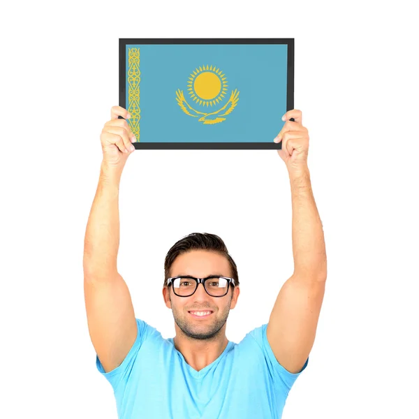 Portrait of a young casual man holding up board with National fl — Stock Photo, Image