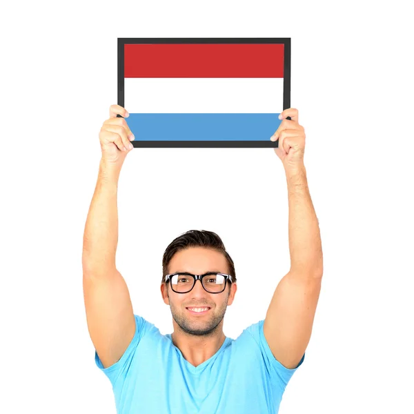 Porträt eines jungen, lässigen Mannes, der eine Tafel mit Nationalflagge hochhält — Stockfoto